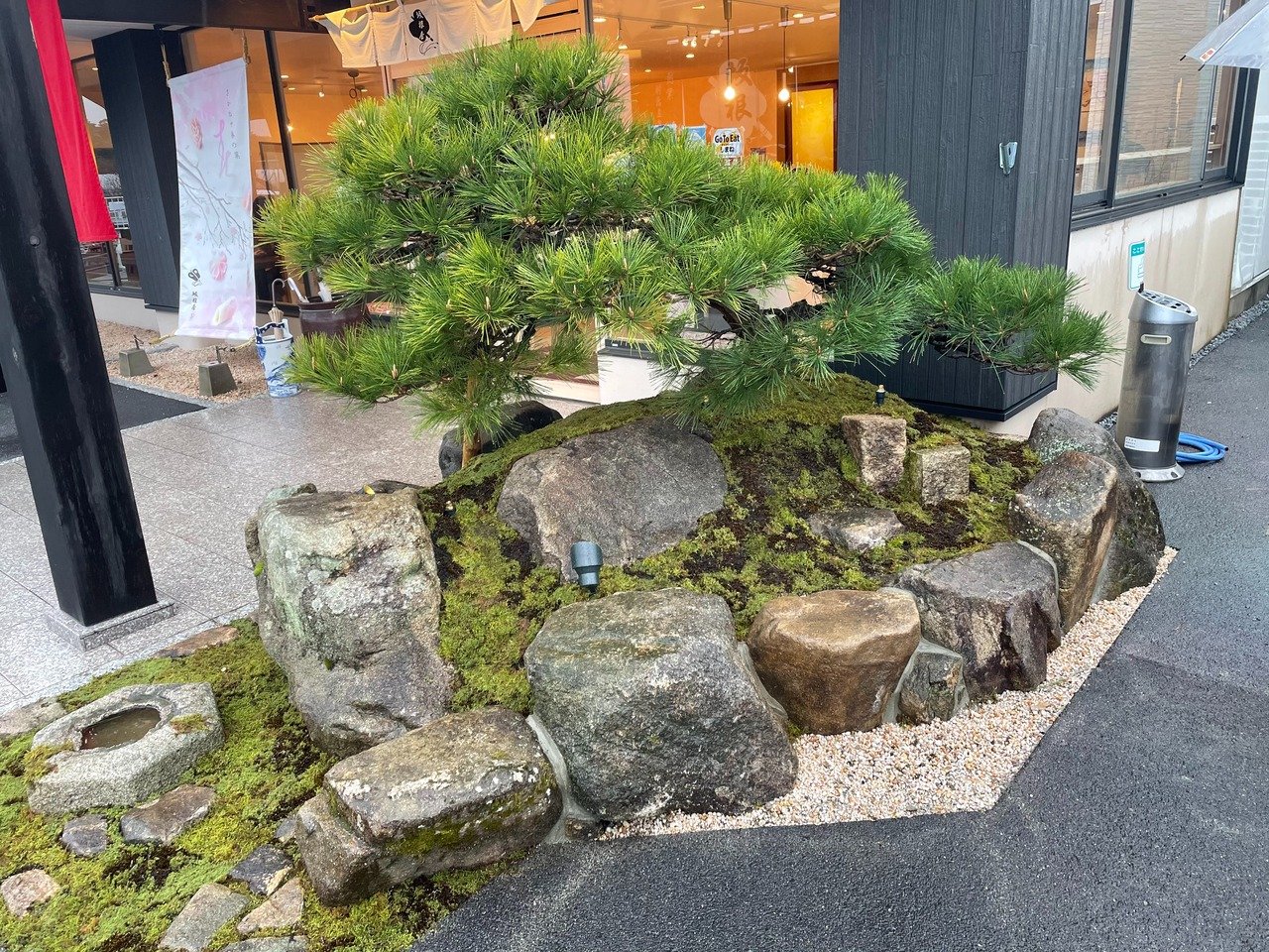 新しい庭木を配置しながら玄関前の植栽計画を確認している現場の様子